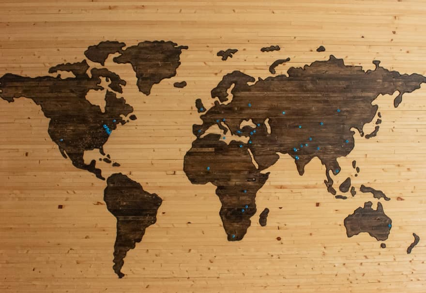 Mapa del mundo de madera colgado en una pared clara
