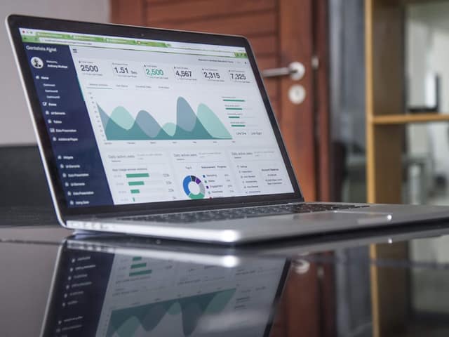Portátil abierto mostrando un panel de analítica con gráficas de tráfico